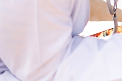 Excited little African boy with hopeful eyes, raised eyebrows and an uneasy smile on his face looking at his pediatrician who is going to inject an intramuscular solution into his arm